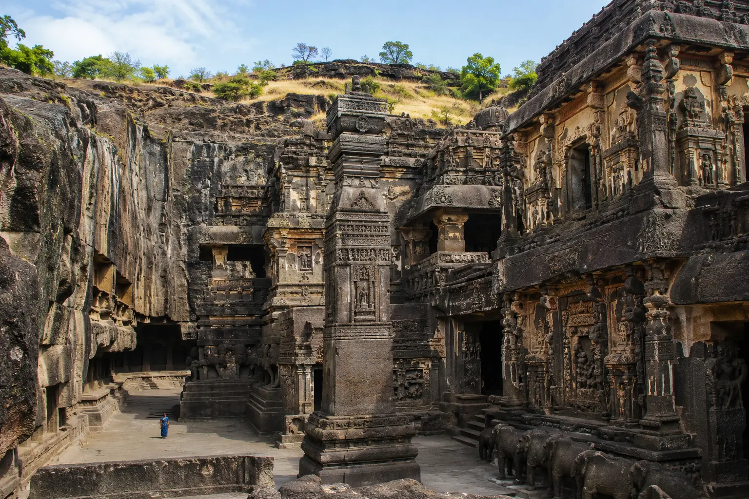 Intricately carved stone pillar and monolithic structures of the Kailasa Temple carved out of a basalt cliff face at Ellora Caves.
